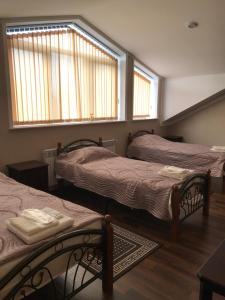 a room with three beds and two windows at Caravan Saray in Makhachkala
