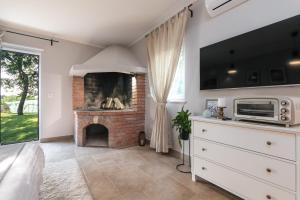 a living room with a fireplace and a tv at Quercus Apartments - Peace & Nature by the Bike Trail in Funtana +16 photos