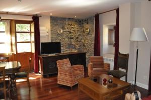a living room with a television and a table and chairs at La Casona de Don Santos in Proaza