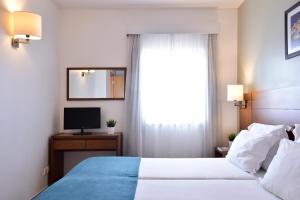 a hotel room with two beds and a television at Aqualuz Lagos by The Editory in Lagos