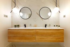 a bathroom with two mirrors above a sink at Nogalera Terrace by Madflats Collection in Torremolinos