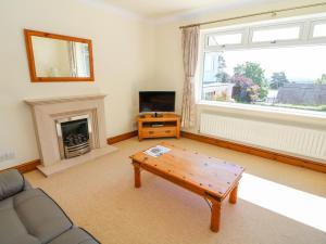 a living room with a couch and a fireplace at Moss Cote in Milnthorpe