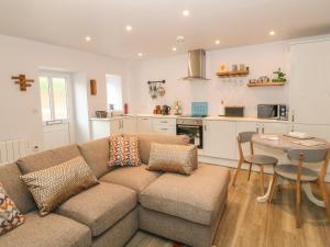 a living room with a couch and a table and a kitchen at 1 Tan Y Gerddi in Machynlleth