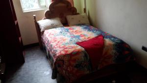 sypialnia z łóżkiem z kolorową kołdrą w obiekcie Zf PENSION w Addis Abebie