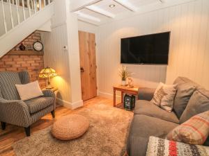 uma sala de estar com um sofá e uma televisão em The Olde Stables em Morpeth