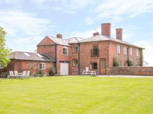 una antigua casa de ladrillo con un gran patio en The Manor House at Kenwick Lodge, en Ellesmere