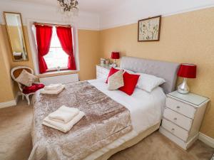 una camera da letto con un letto grande con cuscini rossi di Castle School House a Kidwelly