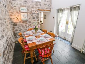 una sala da pranzo con tavolo e sedie in legno di Castle School House a Kidwelly