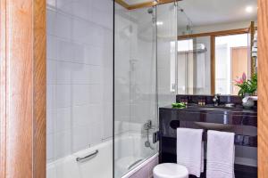 a bathroom with a shower and a toilet and a sink at Aqualuz Lagos by The Editory in Lagos