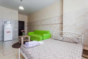a bedroom with a bed and a green chair at Dream Apartments in Kyiv +57 photos