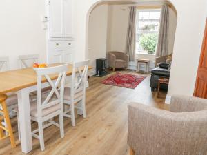 a kitchen and living room with a table and chairs at 1 Castle Row in Beaumaris