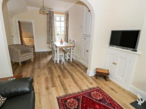 a living room with a table and a tv at 1 Castle Row in Beaumaris