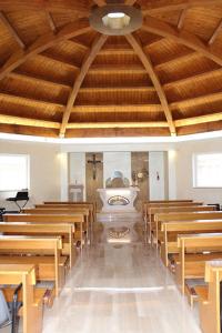 una iglesia con bancos de madera y un altar en una habitación en Oasi di Pace en Sutri