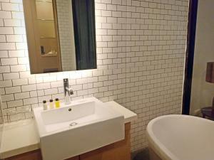a white bathroom with a sink and a mirror at Vismaya Suvarnabhumi Hotel in Lat Krabang