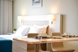 a table with chairs and a bed in a room at Aqualuz Lagos by The Editory in Lagos