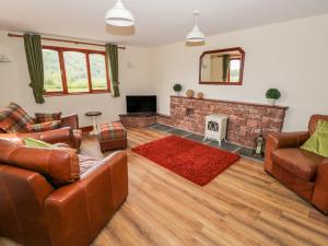 a living room with leather furniture and a fireplace at Green Hills Lodge in Ulverston