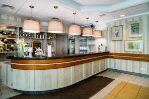 Pomorze Health&Family Resort -Domki całoroczne في أوستكا: وجود بار في مطعم به انارة قلادة