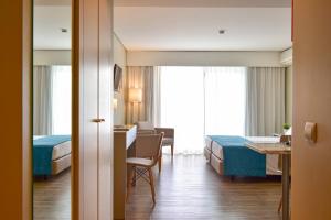 a hotel room with two beds and a desk at Aqualuz Lagos by The Editory in Lagos