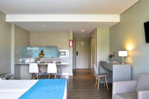 a living room and kitchen with a couch and chairs at Aqualuz Lagos by The Editory in Lagos