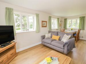 a living room with a couch and a tv at Daisy Cottage in Tenbury