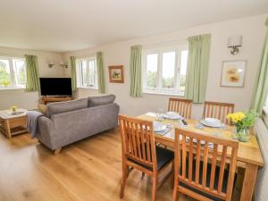 a living room with a table and a couch at Daisy Cottage in Tenbury