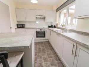 a kitchen with white cabinets and a counter top at Falla Farmhouse in Jedburgh