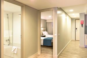 a hotel room with a bed and a bathroom at Aqualuz Lagos by The Editory in Lagos