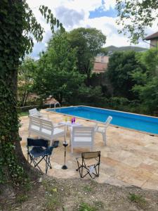 a patio with a table and chairs next to a pool at Maison dans les Cévennes in Saint-Hippolyte-du-Fort +14 photos
