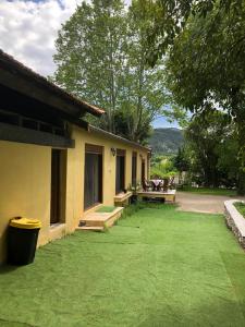 a house with a yard with a bench and a table at Maison dans les Cévennes in Saint-Hippolyte-du-Fort