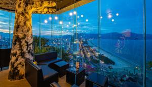 a room with a view of the city through a large window at Sala Danang Beach Hotel in Da Nang