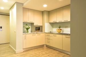 a kitchen with white cabinets and wooden floors at Aqualuz Lagos by The Editory in Lagos
