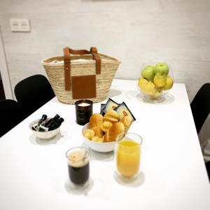 a table topped with bowls of fruit and a basket of oranges at OLA Apartamento - Perla Boutique Apartamentos in Donostia-San Sebastián +9 photos