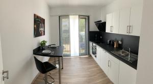 a kitchen with white cabinets and a table and a sink at Main Boarding House in Miltenberg