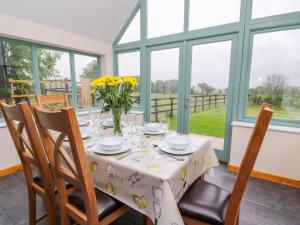 a dining room with a table with yellow flowers on it at Bwthyn Eisteddfa Fach in Cilgwm