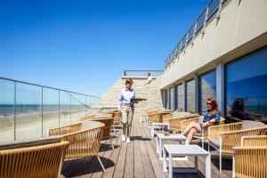 a woman walking down the stairs of a building at ibis Thalassa Le Touquet in Le Touquet-Paris-Plage