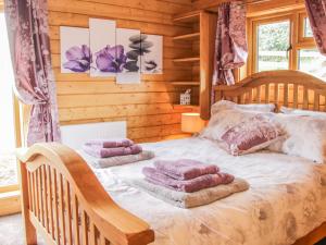 Un pat sau paturi într-o cameră la Manor Farm Lodges - Dragon Lodge