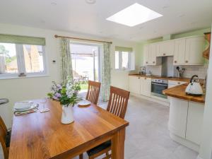 a kitchen and dining room with a wooden table at Treacle Cottage in Warwick