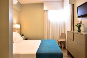 a hotel room with a bed and a television at Aqualuz Lagos by The Editory in Lagos
