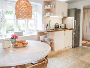 a kitchen with a table with a plate of food on it at Whitehall Farm Cottage in Honiton