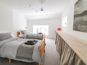 1 dormitorio con 2 camas y un cuadro en la pared en Whitehall Farm Cottage en Honiton