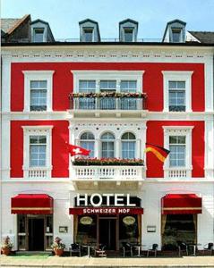 un edificio rosso e bianco con un hotel di Hotel Schweizer Hof - Superior a Baden-Baden