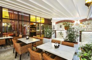 un restaurante con 2 mesas, sillas y plantas en Sunset Hotel - All Inclusive, en Sunny Beach
