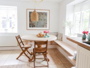 a white kitchen with a table and chairs at Whitehall Farm Cottage in Honiton +21 photos