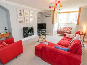 a living room with two red couches and a tv at The Hideaway in Whitby