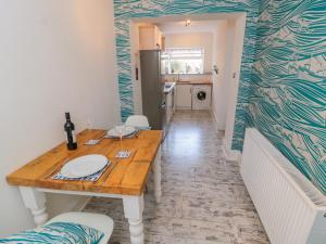 a kitchen with a wooden table in a room at The Hideaway in Whitby +10 photos