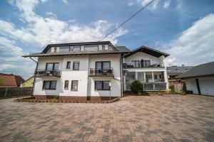 ein großes weißes Haus mit einer Ziegelsteinfahrt in der Unterkunft Hotel Rieder in Wiesemscheid