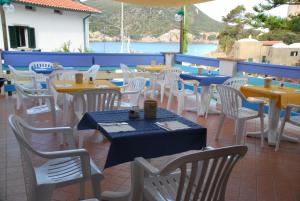 a row of tables and chairs on a patio at Hotel Giardino delle Palme in Campese