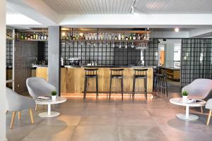 a bar in a restaurant with chairs and tables at Aqualuz Lagos by The Editory in Lagos