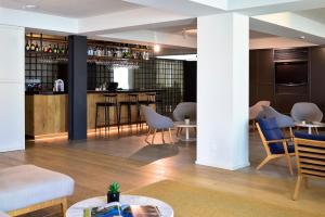 a living room with a bar and some chairs at Aqualuz Lagos by The Editory in Lagos