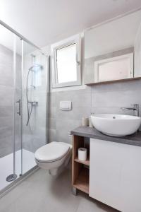 a bathroom with a sink and a toilet and a shower at Mobile Homes at Camping Ugljan Resort in Ugljan
